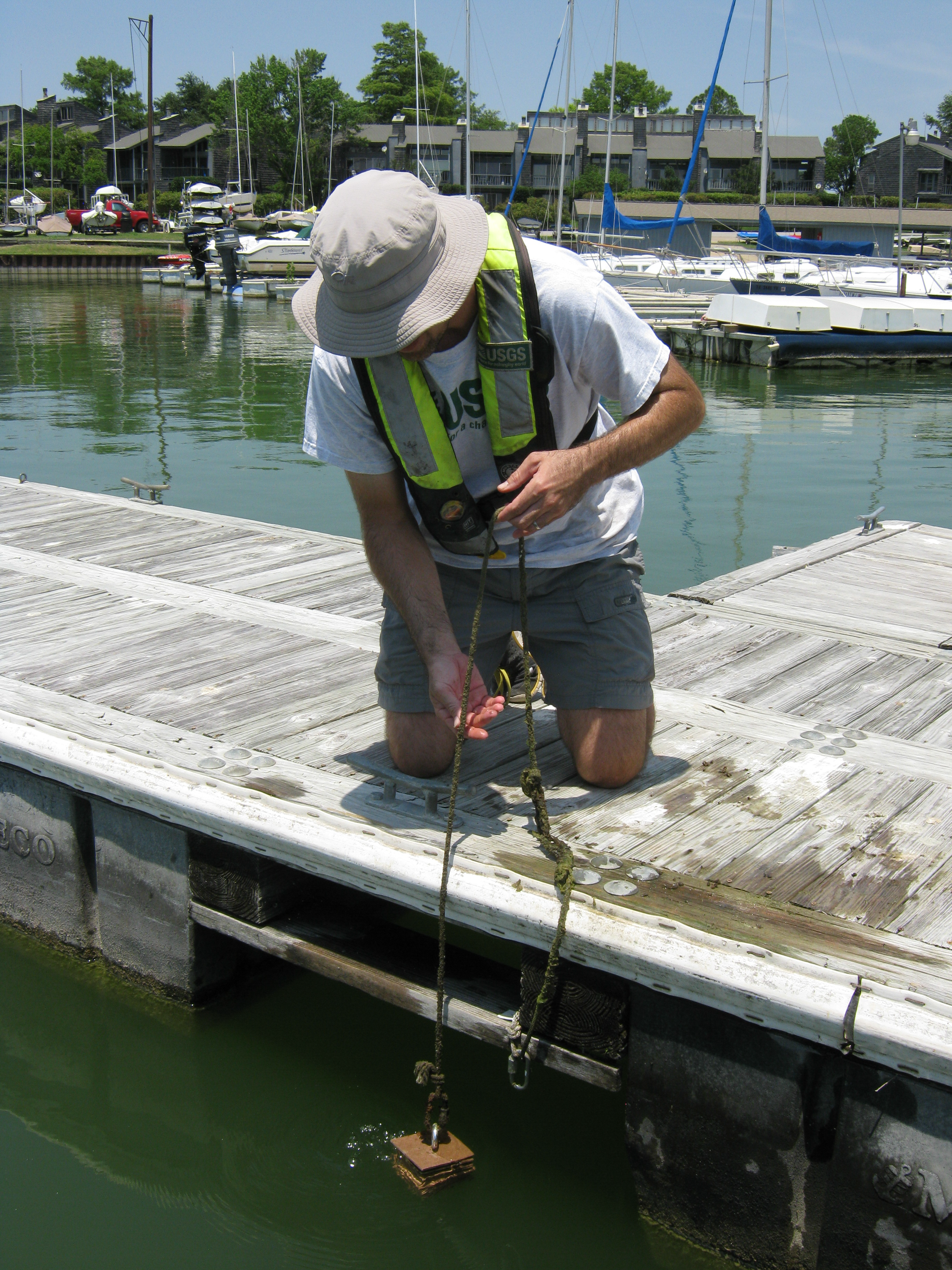 USGS scientist lowering artificial substrate into the lake